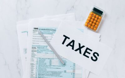 Top view of tax forms, a calculator, and pen for tax preparation.