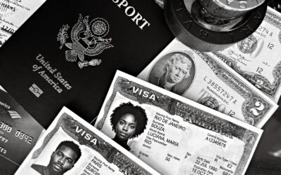 A black and white composition of a US passport, visas, and currency, showcasing travel essentials.
